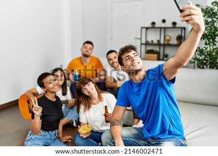 Group of young friends on party smiling happy make selfie by the smartphone at home.