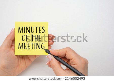 Closeup on businesswoman holding a card with text MINUTES OF THE MEETING, business concept image Royalty-Free Stock Photo #2146002493