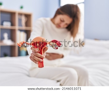 Young woman suffering for period pain sitting on bed at bedroom Royalty-Free Stock Photo #2146011071