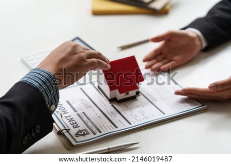 Close up Businessman or agent giving house after signing agreement for buying house. Bank manager and real estate concept.