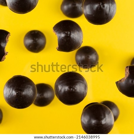 esthetic photo of cookies in chocolate of round shape with a nut on a yellow background, top view