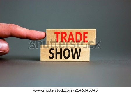 Trade show symbol. Wooden blocks with concept words Trade show on beautiful grey background. Businessman hand. Business economic financial trade show concept. Copy space.