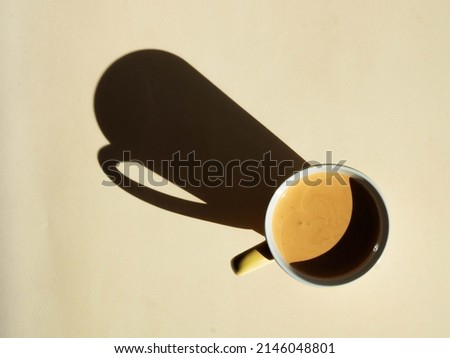 Cappuccino coffee mug on beige with clear shadows in hard light. Minimalism natural colors. View from above. Place for text.