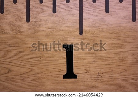 Vintage traditional wooden school ruler with inches as a measurement system and the number 1.