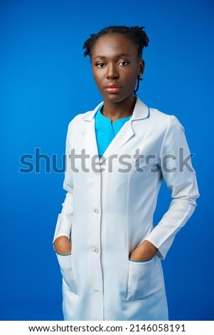 Portrait of young african female doctor in blue studio