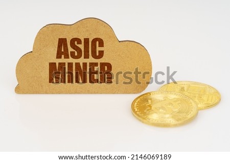 Business and technology concept. Bitcoins lie on a white surface and there is a sign - a cloud with the inscription - Asic miner