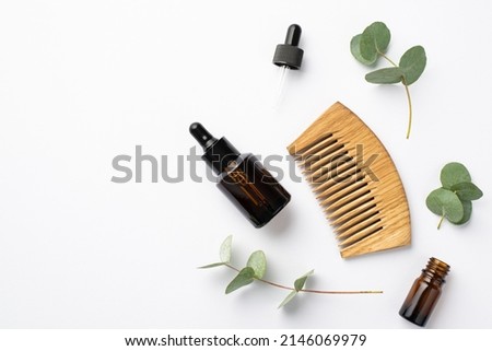 No plastic concept. Top view photo of glass dropper bottles wooden hairbrush and eucalyptus leaves on isolated white background with empty space Royalty-Free Stock Photo #2146069979