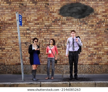 Hes just got a bad feeling about today..... A black rain cloud over the young mans head standing at the bus stop.