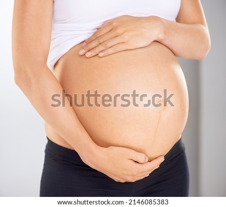 I love you already. Cropped image of a pregnant woman holding her stomach affectionately.