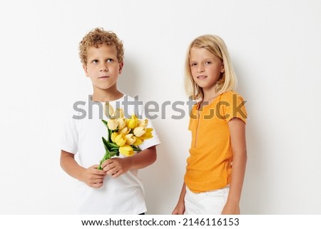 picture of positive boy and girl holiday friendship with a gift Yellow flowers light background