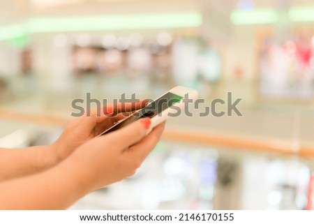 Hands using mobile smart phone and take a photo in display view of a clothing store, shopping online concept