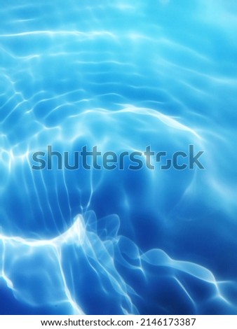 Reflection​ on​ surface​ blue​ water​ in​ the​ sea. Abstract​ of​ surface​ blue​ water​ for​ background. Closeup​ abstract​ of​ surface​ blue​ water pattern​. Splash​ed​ water​ in the​ swimming  pool.