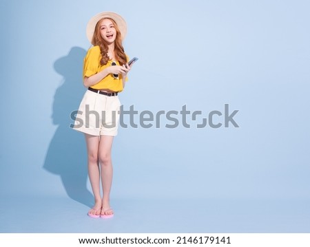 Portrait of young Asian girl on blue background, summer vacation concept