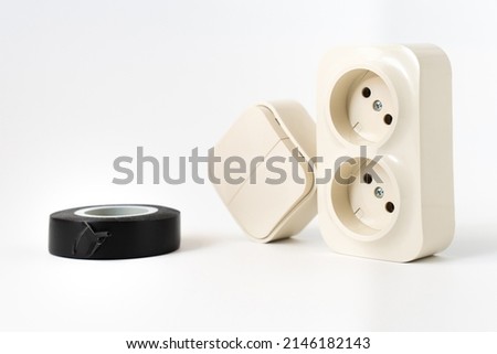 black insulating tape, double socket and two-key light switch on white background. mechanical device for switching lighting circuit, two sockets connected by monolithic case.shop of electronic devices Royalty-Free Stock Photo #2146182143