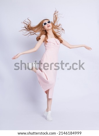 Full length image of young Asian woman wearing dress on white background