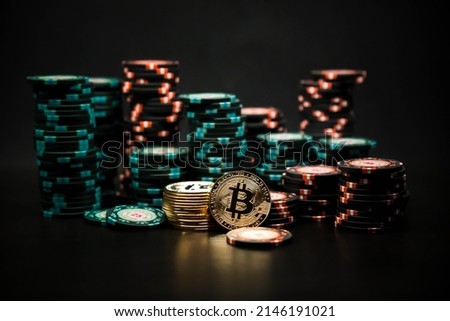 Bitcoin coins on the background of a slide of casino chips on a black background. Bitcoin casino game. Cryptocurrency excitement. Bet on bitcoins. Royalty-Free Stock Photo #2146191021