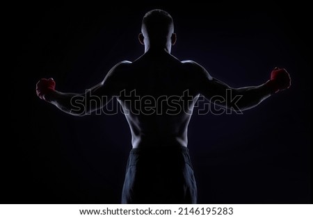 Kickboxer in red bandages raised his hands in victory. Back view. The concept of mixed martial arts. MMA