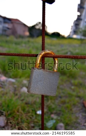 Single rusty love padlock hanging on a grid, eternity love concept.  