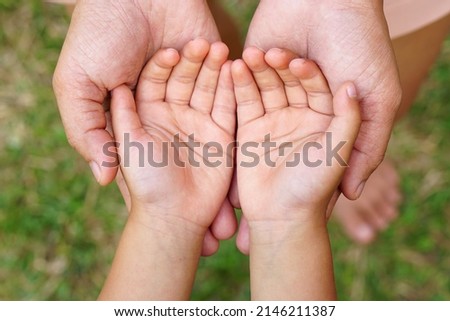 Mother and Child’s holding hands to receive something