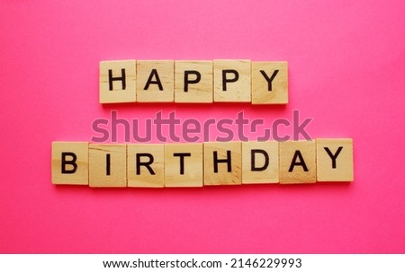 Happy Birthday Word of wooden cubes on a pink background. Congratulation. Holiday. postcard. Copy space. Top view. Flat lay