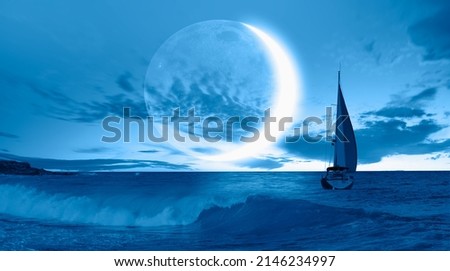 A lonely yacht sails on the sea,  Crescent or new moon  in the background  Royalty-Free Stock Photo #2146234997