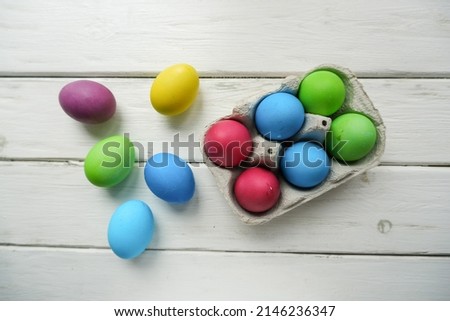Easter eggs on a light wooden background. Multi colored Easter eggs, photo from above. Horizontal spring background for Easter greetings.