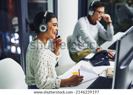 Taking care of their customers. Shot of young call centre agents working late in an office. Royalty-Free Stock Photo #2146239197