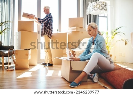 Packing up memories. Shot of a mature couple packing boxes on moving day. Royalty-Free Stock Photo #2146239977