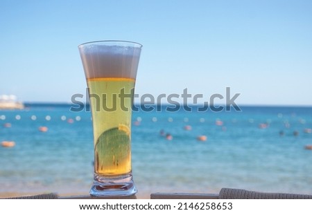 a glass of beer on the background of the sea