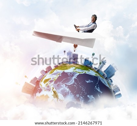 Businessman in aviator hat sitting in paper plane and holding steering wheel. Pilot driving paper plane in cloudy blue sky. Spherical view of modern city with high skyscrapers and sea line.