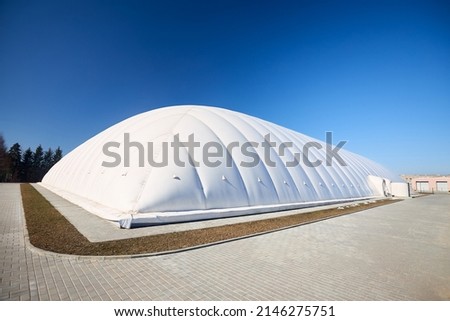 Inflatable air dome stadium. Inflated Tennis air dome or Tennis bubble arena. Modern urban architecture example as pneumatic stadium dome. Royalty-Free Stock Photo #2146275751