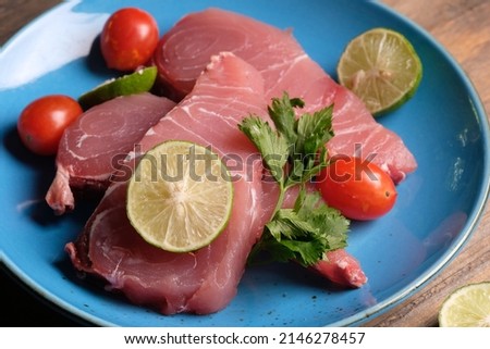 fish fillet on blue ceramic plate. fillet is fish meat that has been cut or sliced away from the bone by cutting lengthwise along one side of the fish parallel to the spine. Istiompax indica. Marlin

