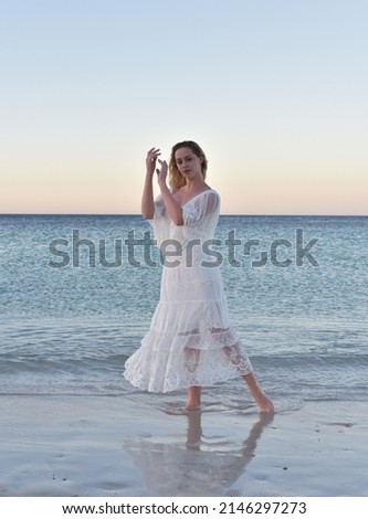 Portrait of beautiful girl wearing flowing  fantasy gown in a magical lake background.