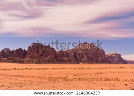 Landscape with sandstone mountains over Wadi Rum desert in Jordan with blue sky.