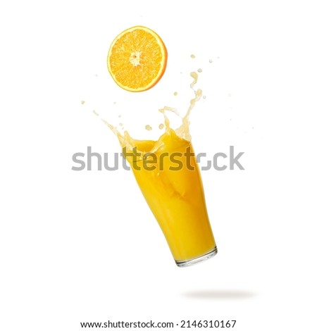 Orange fruit slice and juice glass with splash and drops flying falling isolated on white background. Healthy drink. Royalty-Free Stock Photo #2146310167