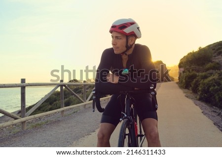 Cyclist in a break on a road at sunset during a training session. Royalty-Free Stock Photo #2146311433