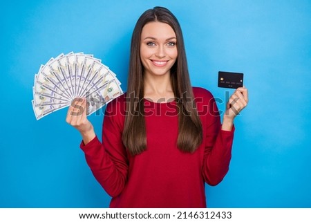 Photo of cool young lady hold cash card wear burgundy jumper isolated on blue color background
