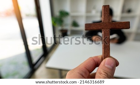 holding a cross Praying for God's Blessings. Christianity. Cross and Faith Concepts. with the spirit and Christian belief and faith
