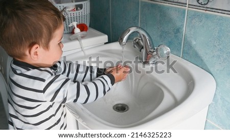 Cute little boy washing his hands in bathroom. Morning hygiene concept