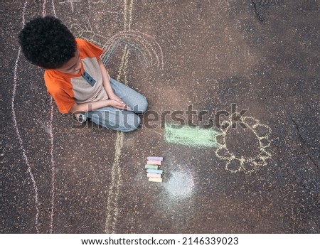 Young boy drawing a flower with chalks on his driveway. Earth day and World environment day concept. copy space