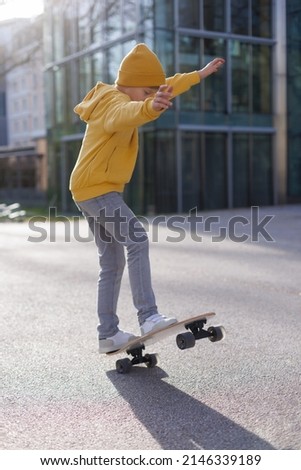 A little skater doing a jump on his skateboard. Outdoors activity concept. Lifestyle scene