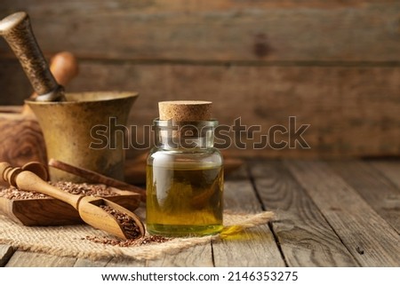 Flaxseeds and linseed oil. Linseed oil with kitchen utensils on an old wooden table.  Copy space.  Royalty-Free Stock Photo #2146353275