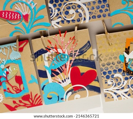 bags decorated with collage of summer themed fish. Paper crafts. 