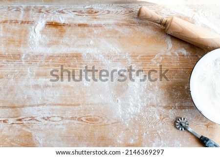 Top view of the rolling pin, plate and flour on the wooden table. Bakery concept. Stock photo 