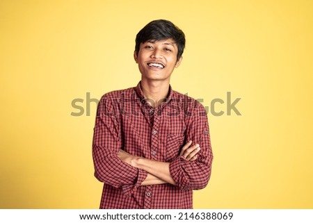 man wearing black t-shirt smiling with arms crossed