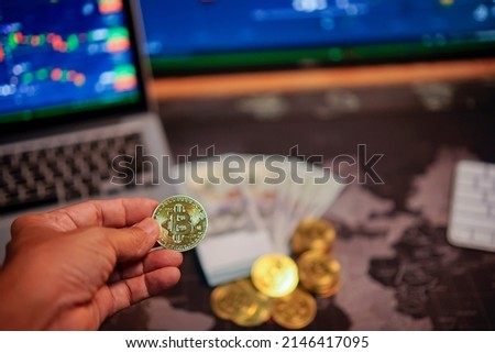 Bitcoin gold coins in the hands of a stockist with blurry chart background The concept of virtual currency