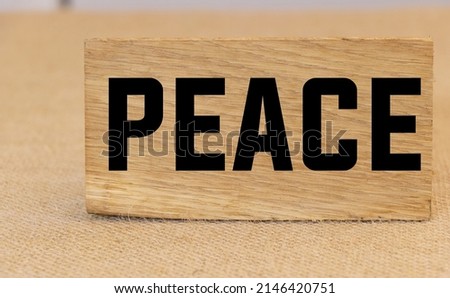 Peace text written on a piece of wood concept.