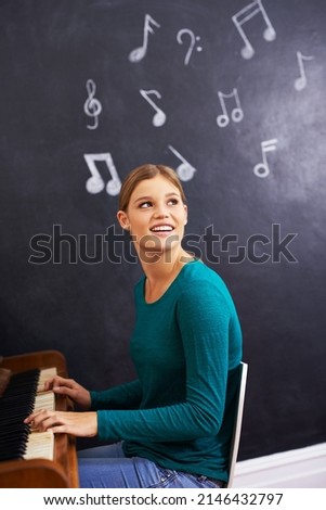 Making music. Shot of a woman playing the piano against a background of musical notes.