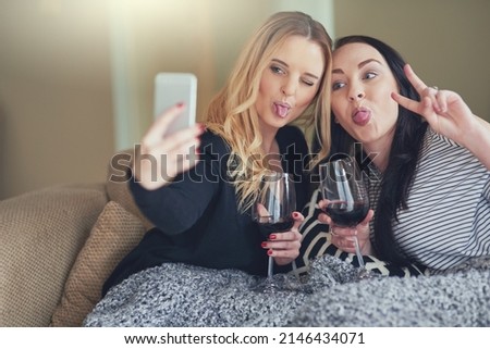 Life is better when youre crazy together. Shot of two young friends taking a funny selfie together at home.