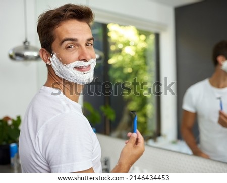 The cream before its all gone. Cropped shot of a handsome man about to shave his beard in the bathroom at home. Royalty-Free Stock Photo #2146434453